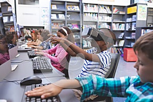 Schoolboy using virtual reality headset in computer room