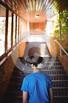 Schoolboy using virtual reality headset on staircase