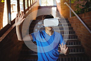 Schoolboy using virtual reality headset on staircase