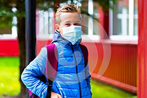 Schoolboy wearing protective mask Standing near school. students are ready for second pandemic wave