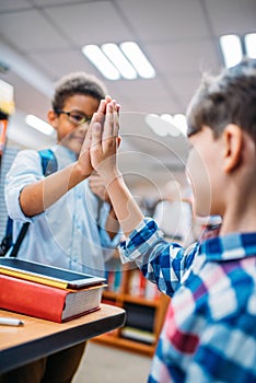 close-up shot of schoolboys giving high five photo