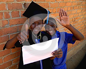 Schoolboys in school uniform and graduation attire holding copyspace.