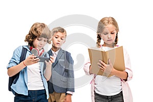 Schoolboys with smartphone and schoolgirl with book photo