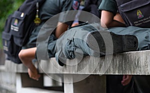 Schoolboys wear military students uniform sleeping on a bench made of cement photo