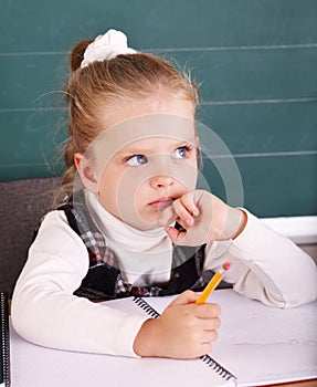 Schoolchild in classroom near blackboard. photo