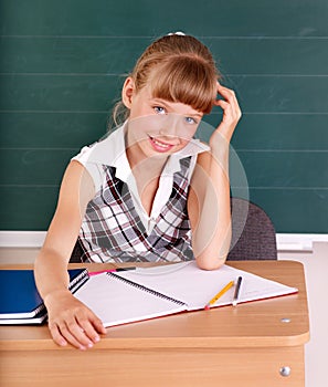 Schoolchild in classroom near blackboard.