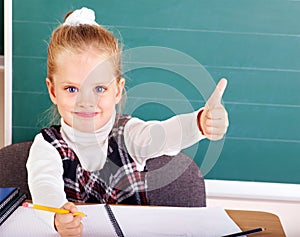 Schoolchild in classroom near blackboard. photo