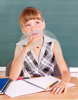 Schoolchild in classroom near blackboard. photo