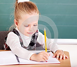 Schoolchild in classroom near blackboard. photo