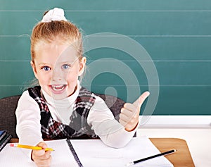 Schoolchild in classroom near blackboard. photo