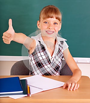 Schoolchild in classroom near blackboard. photo