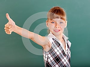 Schoolchild in classroom near blackboard.