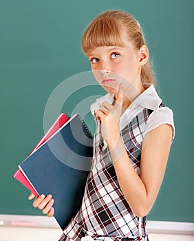 Schoolchild in classroom near blackboard.