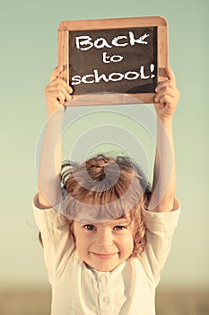 Schoolchild holding small blackboard