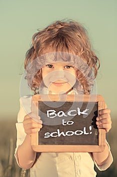 Schoolchild holding small blackboard