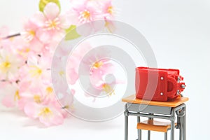 Schoolchild`s rucksacks and cherry blossoms on white background. Red randoseru.