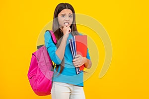 Schoolchild, teenage student girl hold book on yellow  studio background. School and education concept. Back to