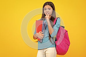 Schoolchild, teenage student girl hold book on yellow  studio background. School and education concept. Back to