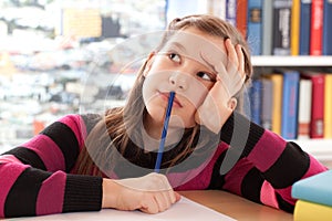 Schoolchild thinking while doing homework photo