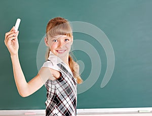 Schoolchild writing on blackboard.