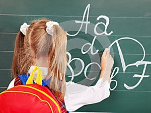 Schoolchild writting on blackboard