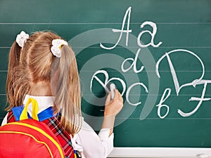 Schoolchild writting on blackboard photo