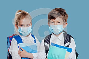 Schoolchildren in face masks with copybooks during coronavirus