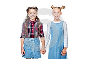 schoolchildren holding hands and looking at camera