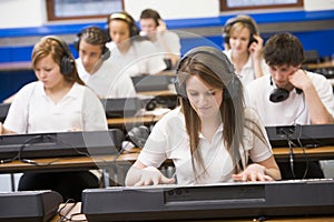 Schoolchildren practicing keyboard in music class