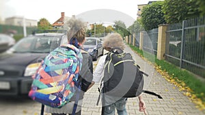 Schoolchildren run from school with backpacks. Happy childhood, Sorceresses, hooligans.