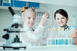 Schoolchildren with science lab equipment in chemical lab