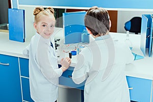 Schoolchildren with science lab equipment in chemical lab