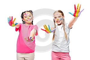 schoolchildren showing painted colorful hands and looking at camera