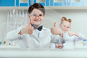 Schoolchildren showing thumbs up in chemical lab