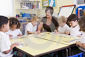 Schoolchildren and their teacher reading in primar