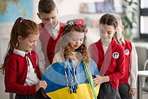 Schoolchildren welcoming new Ukrainian classmate, concept of enrolling Ukrainian kids to schools.