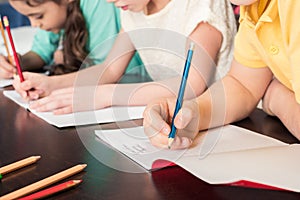 Schoolchildren writing with pencils