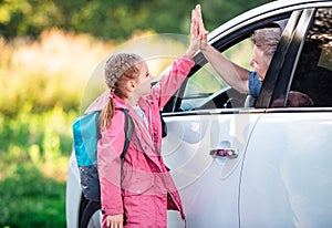 Schooler giving five to father in car photo