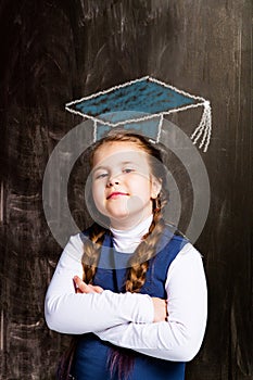 Schoolgirl against chalkboard, with drawn cap