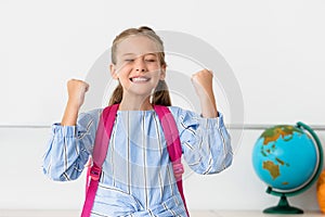 Schoolgirl with backpack showing yeah gesture