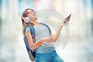 Schoolgirl with bag, backpack. Portrait of modern happy teen school girl with bag backpack headphones and tablet.