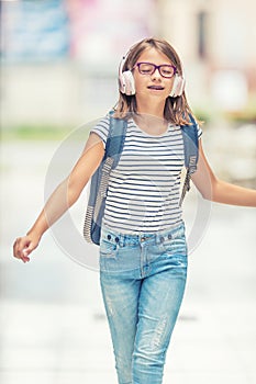 Schoolgirl with bag, backpack. Portrait of modern happy teen school girl with bag backpack headphones and tablet.