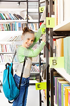Schoolgirl with blue bag searching books