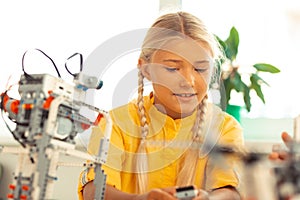 Schoolgirl building a construction set model at the lesson.