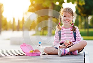 Schoolgirl child eating lunch apples at school