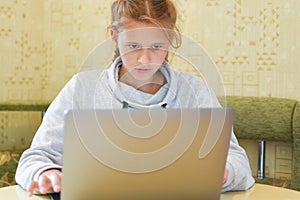 Schoolgirl doing homework at computer, online learning distance.