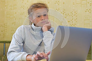 Schoolgirl doing homework at computer, online learning distance.