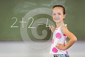 Schoolgirl doing mathematics on chalkboard in classroom