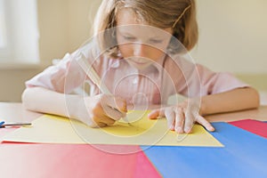 Schoolgirl drawing writing in pen on colored paper