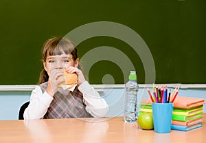Schoolgirl eating fast food during lunch break
